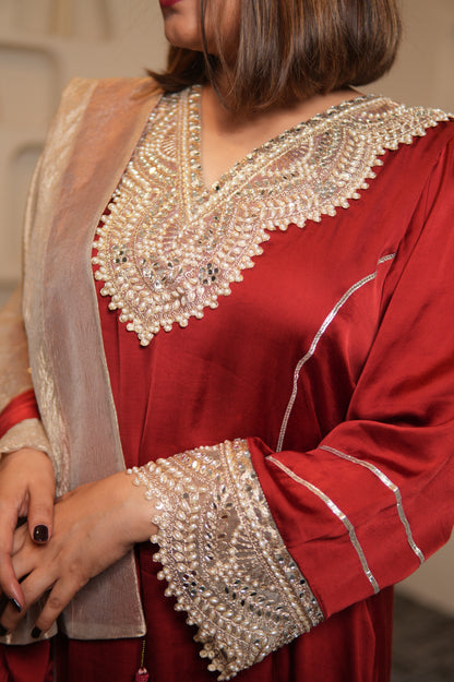 Red garment with intricate white embroidery on a blurred background