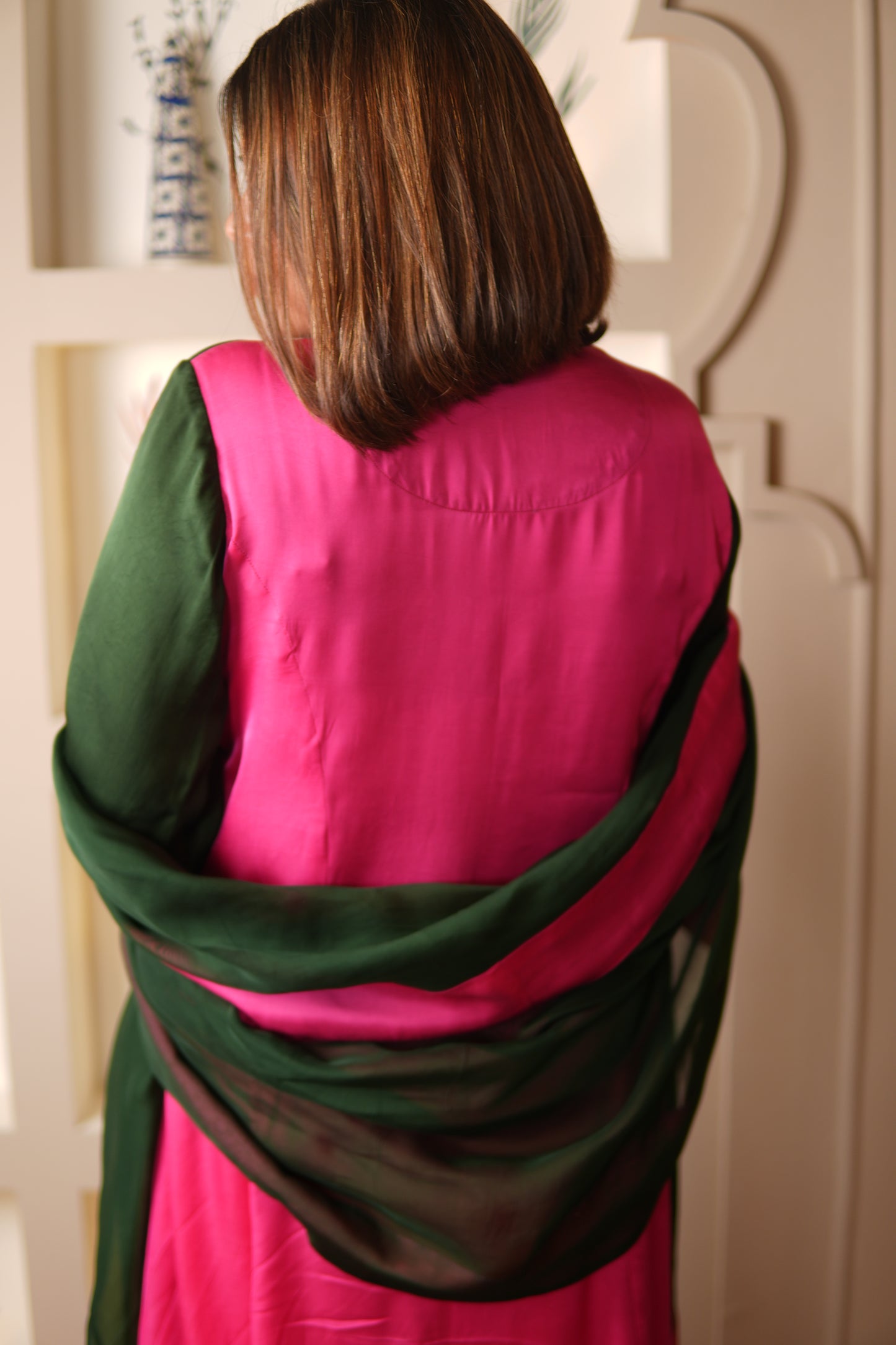 Person wrapped in a pink and green  suit with matching dupatta