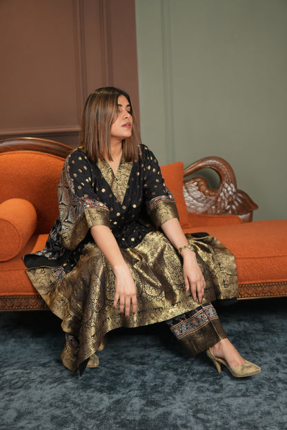 Woman in a patterned dress sitting on an ornate chair with a blurred background